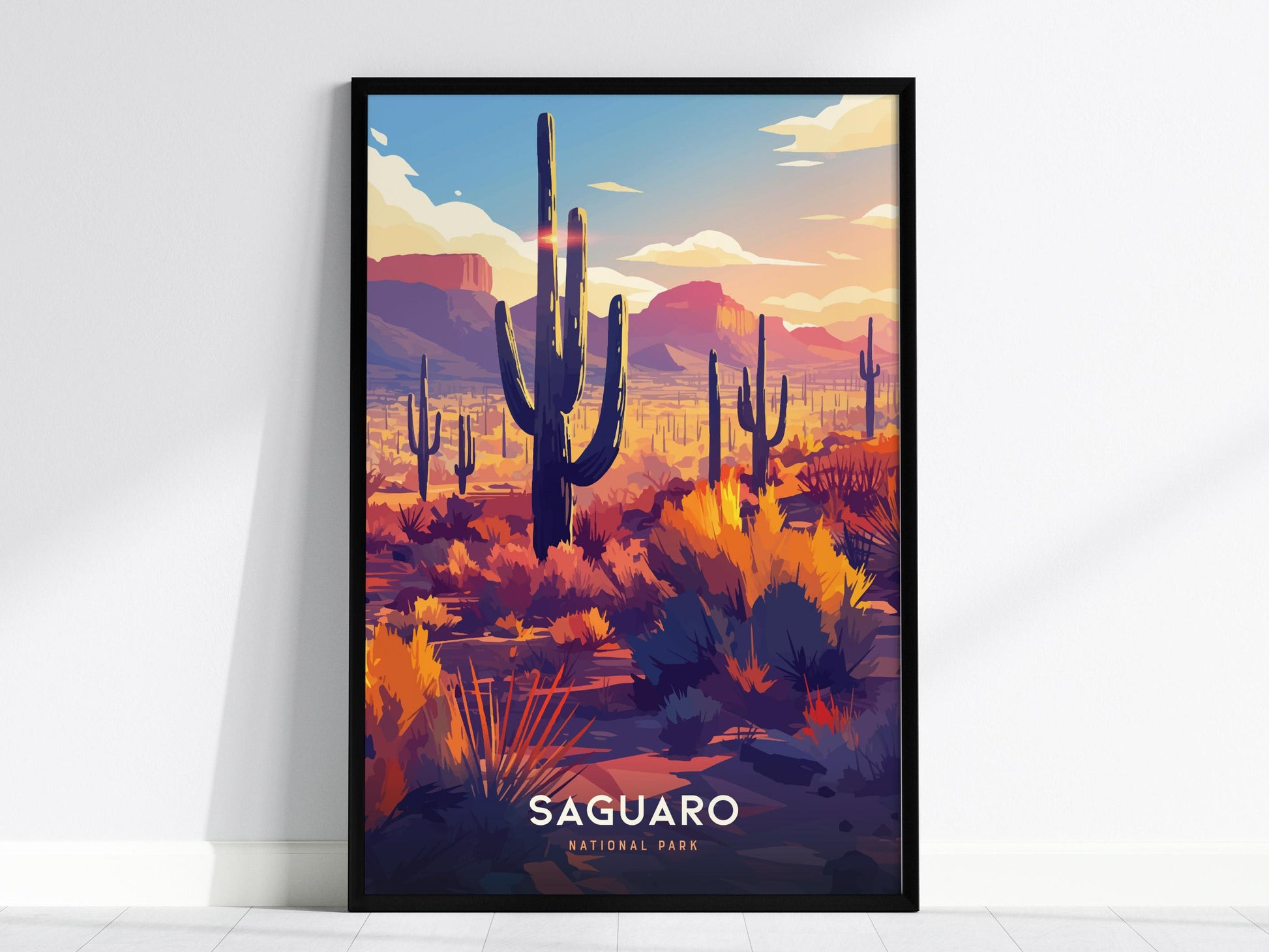 Framed artwork of a desert landscape with cacti, labeled 'Saguaro', on a white wall.