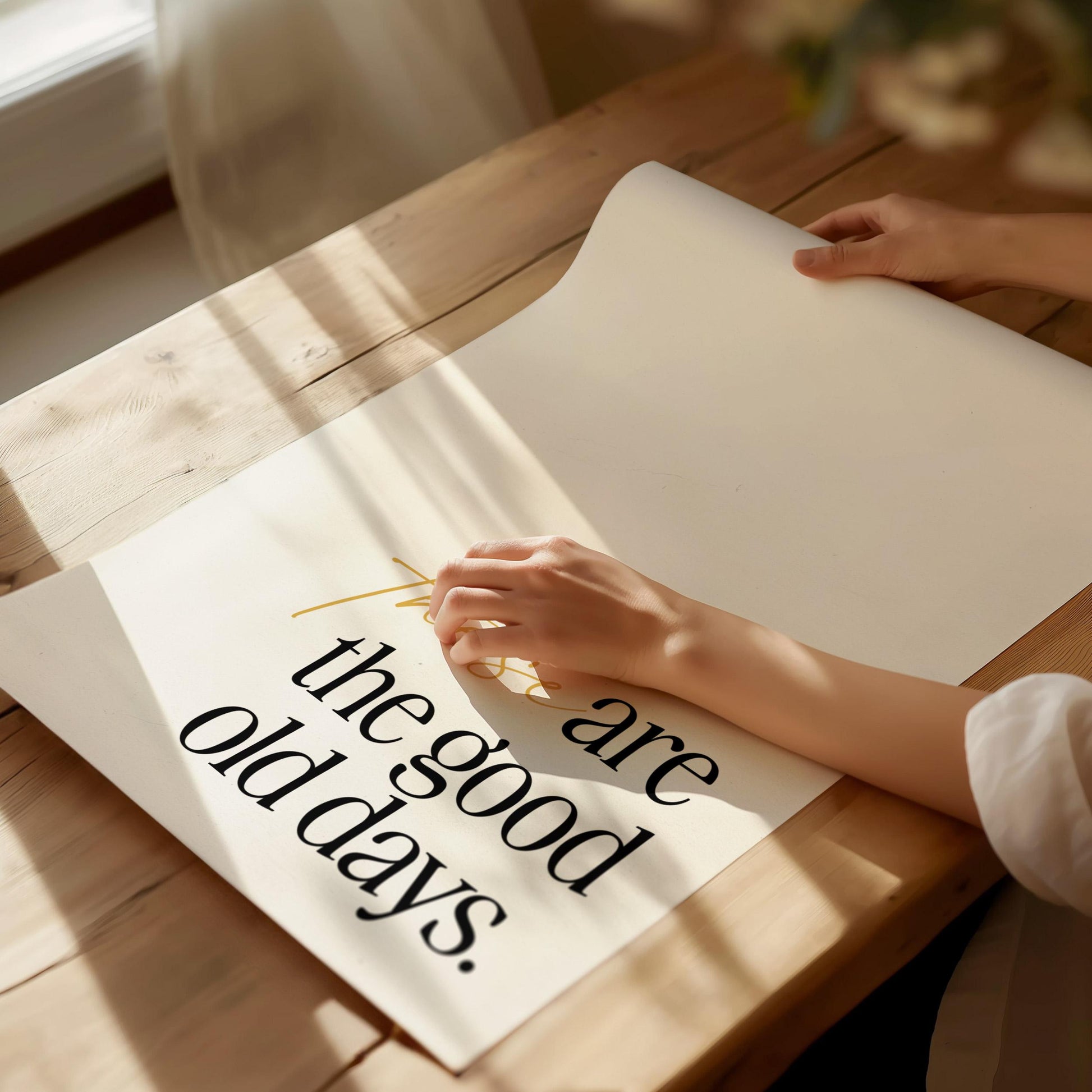 Person holding a piece of paper with 'the good old days' text on a wooden table.
