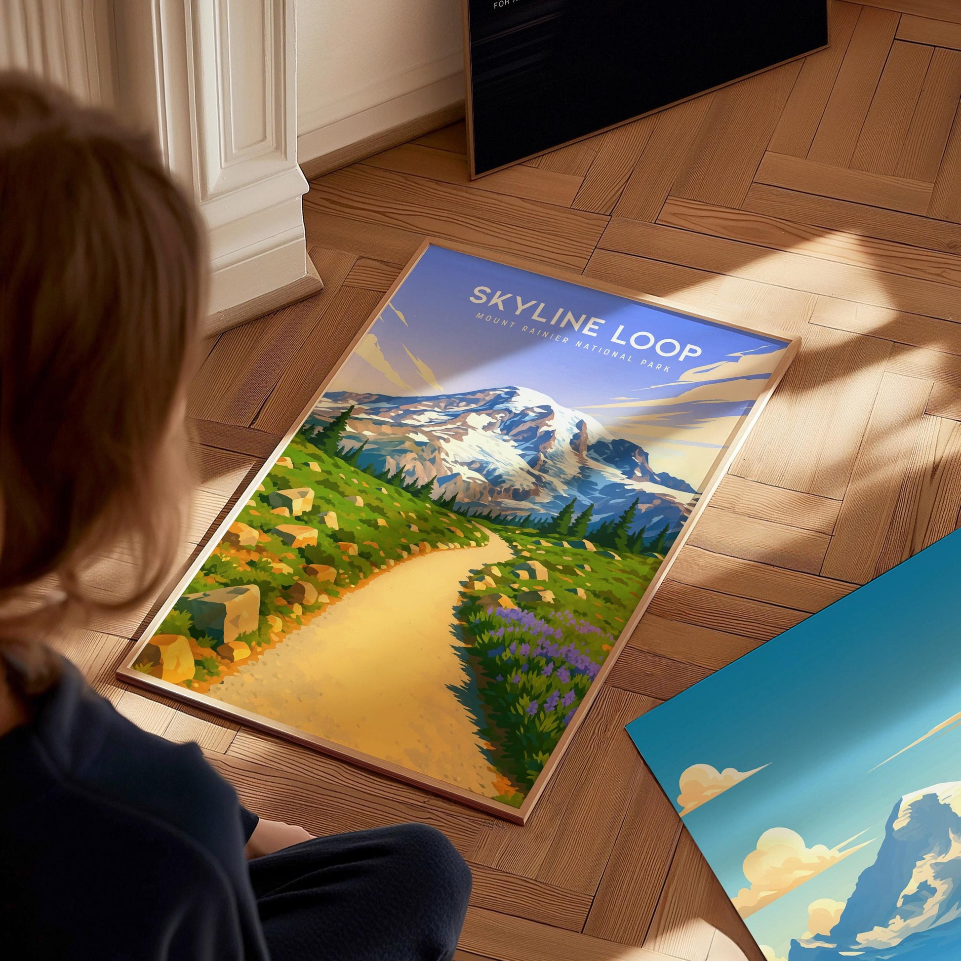 Person looking at a 'Skyline Loop' travel poster on a wooden floor