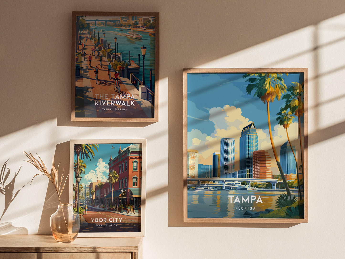 Framed posters of Tampa landmarks on a wall with sunlight casting shadows.