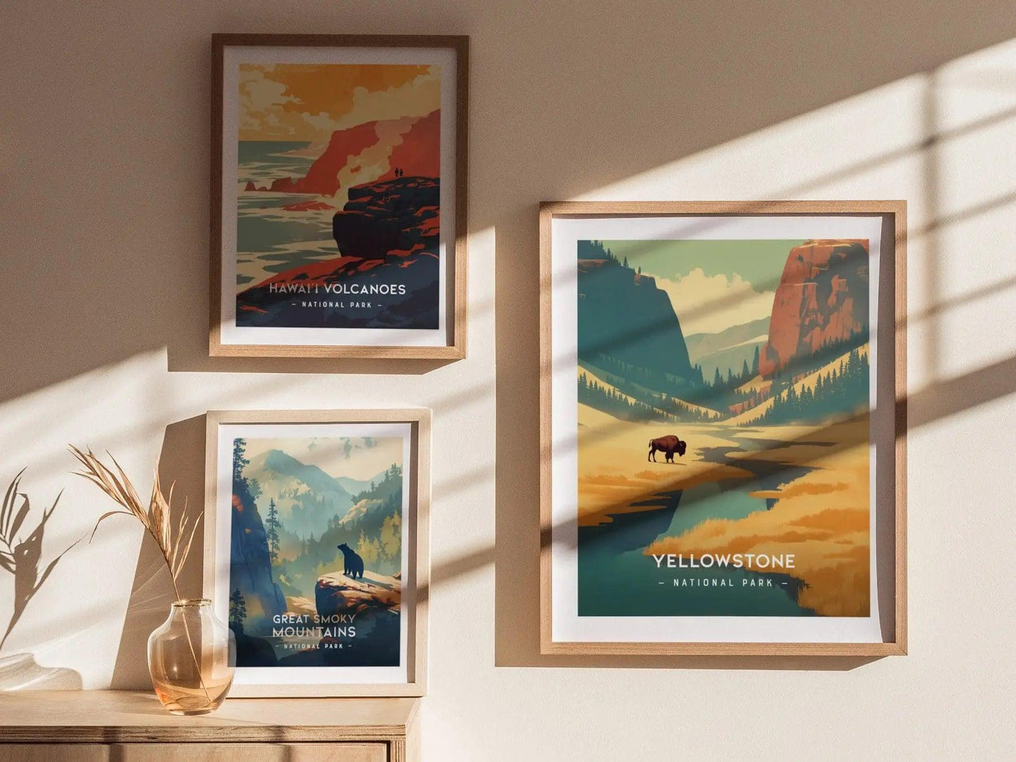 Three framed posters of national parks on a wall with sunlight casting shadows.