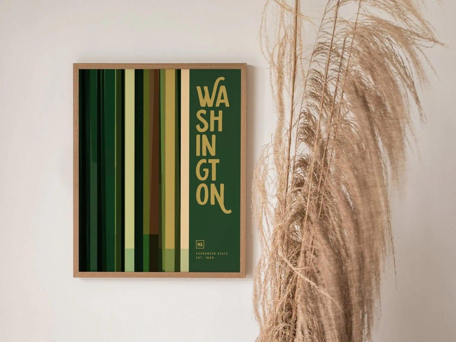 Framed artwork with 'WASHINGTON' text on a green background, leaning against a wall with decorative plants.