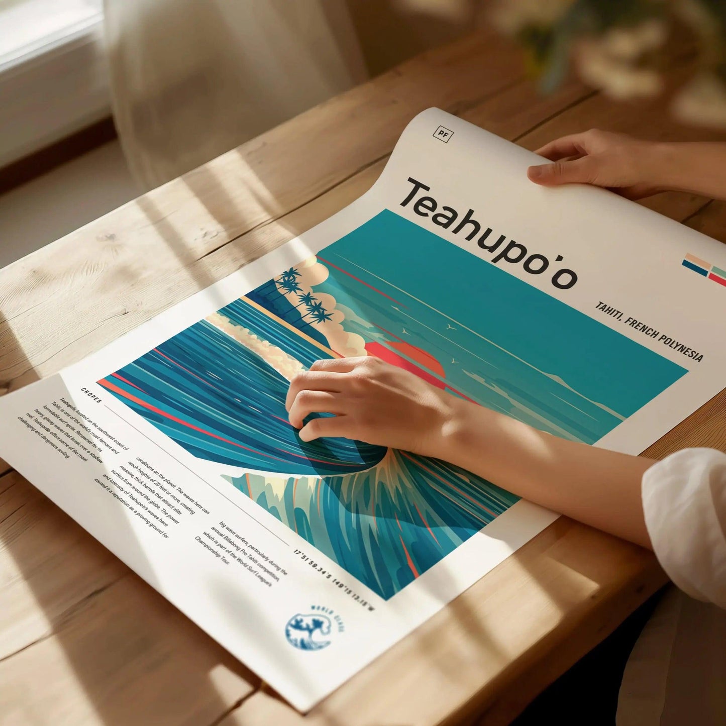 Person holding a magazine with 'Teahupo'o' on a wooden table