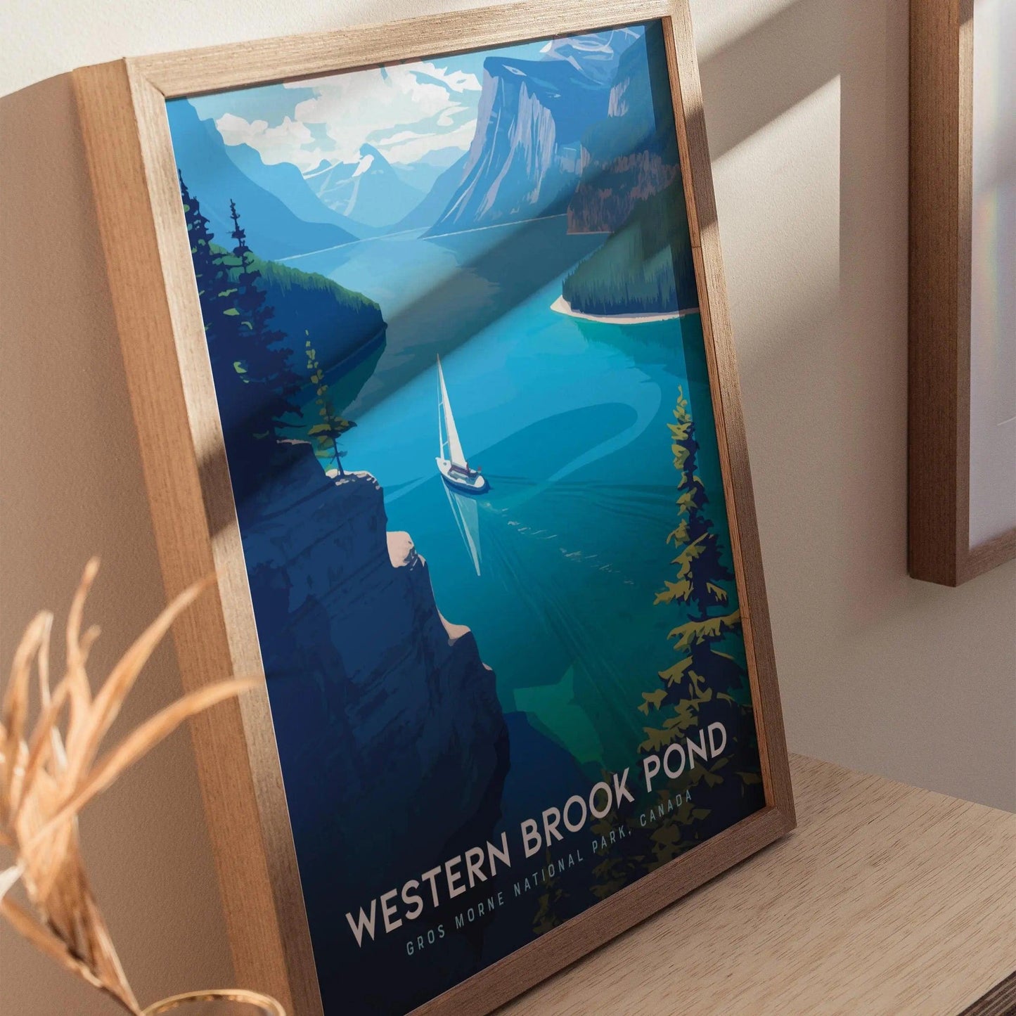 Framed poster of Western Brook Pond with a sailboat on a mountain lake.