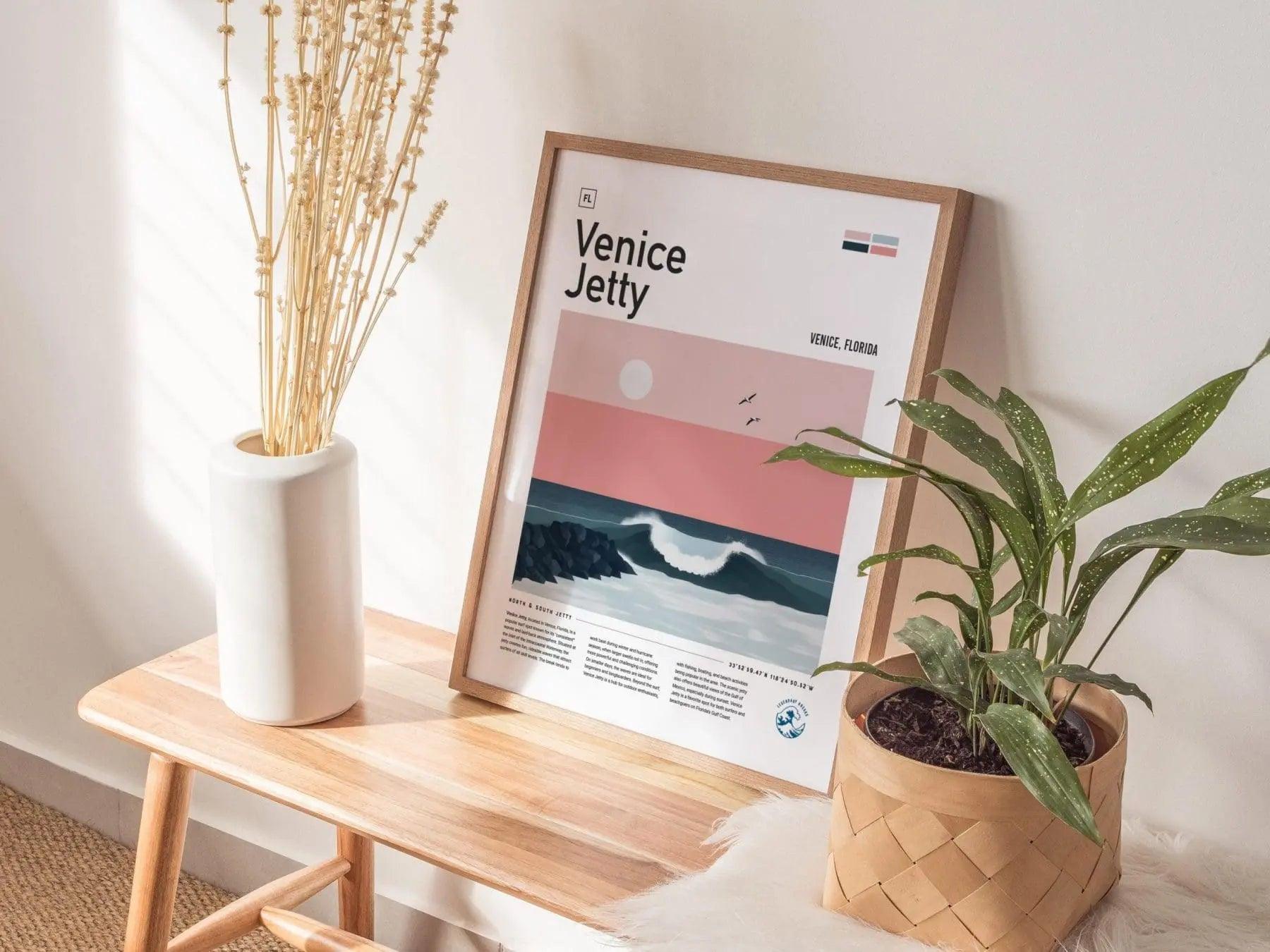 Framed poster of Venice Jetty on a wooden side table with plants and a vase.