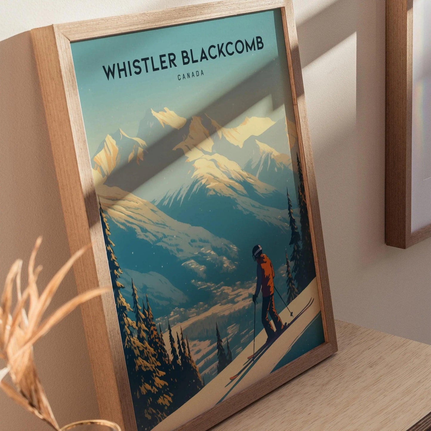 Framed poster of a skier at Whistler Blackcomb, Canada on a wooden surface.