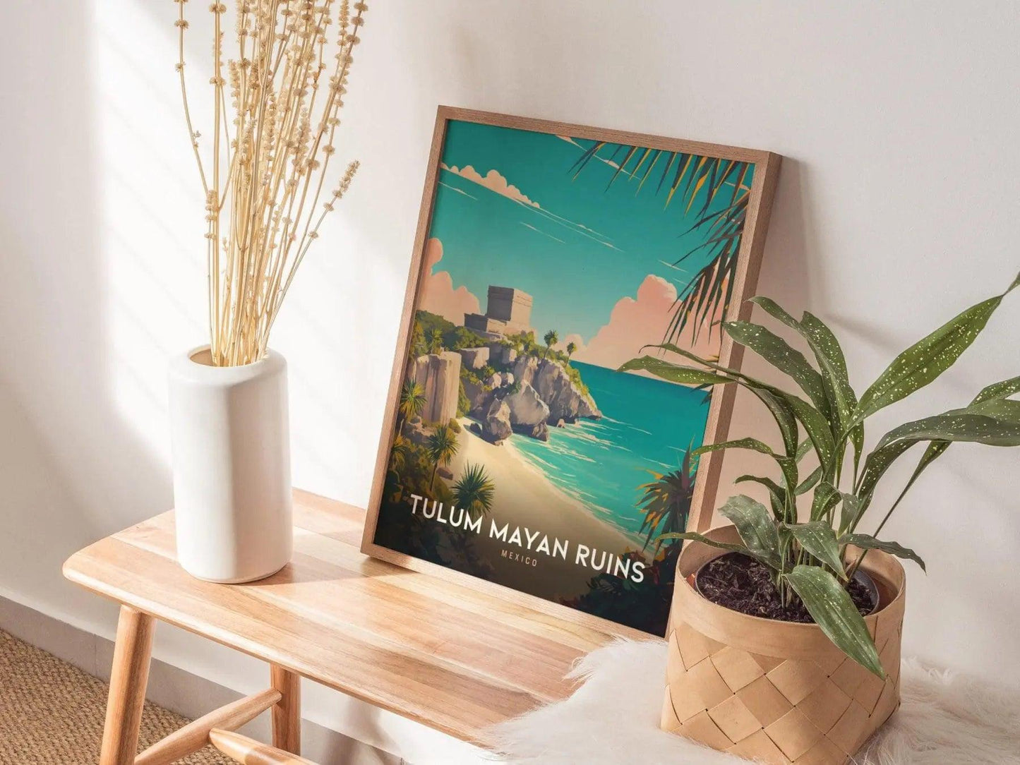 Framed poster of Tulum Mayan Ruins on a wooden table with plants and a vase.
