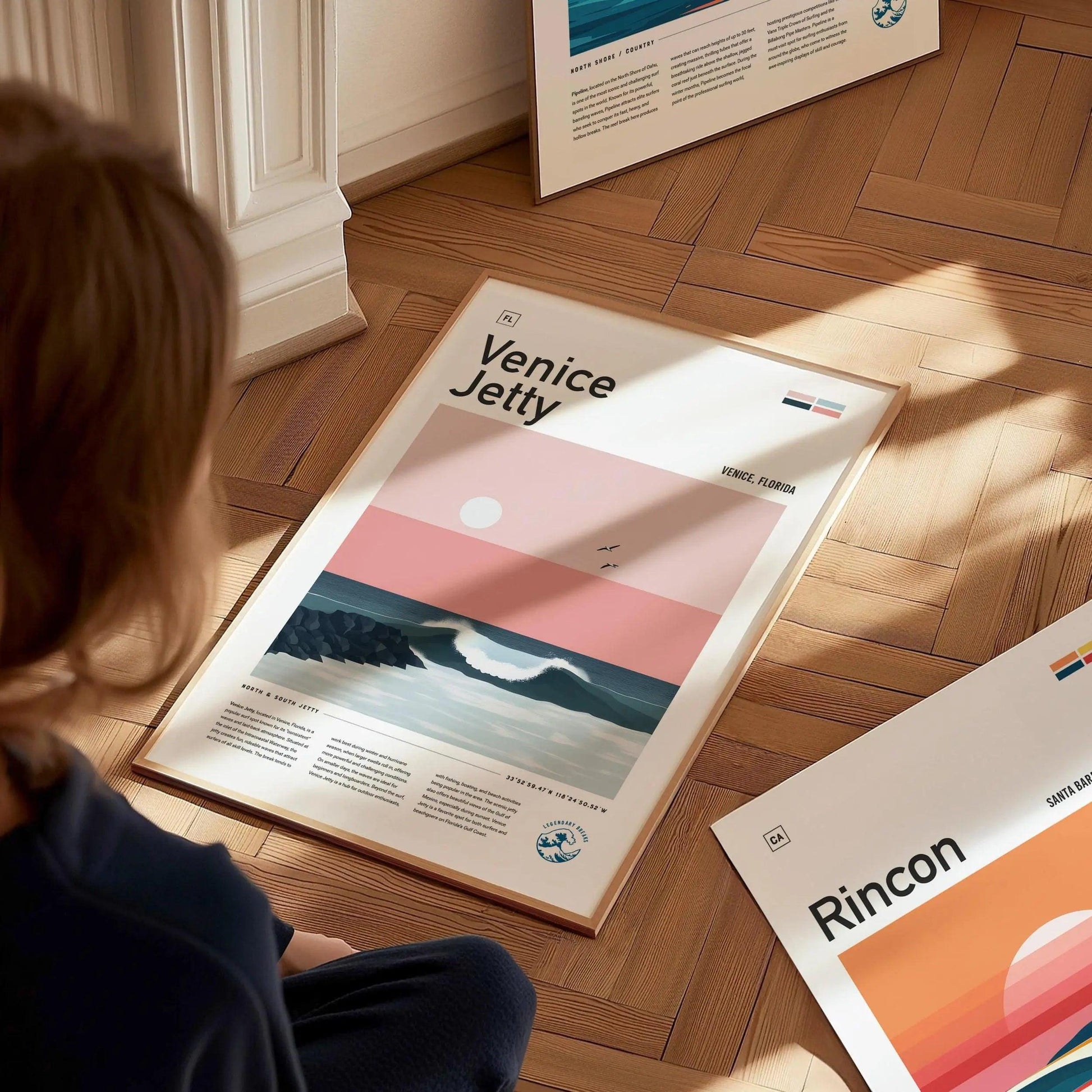 Person looking at a Venice Jetty poster on a wooden floor