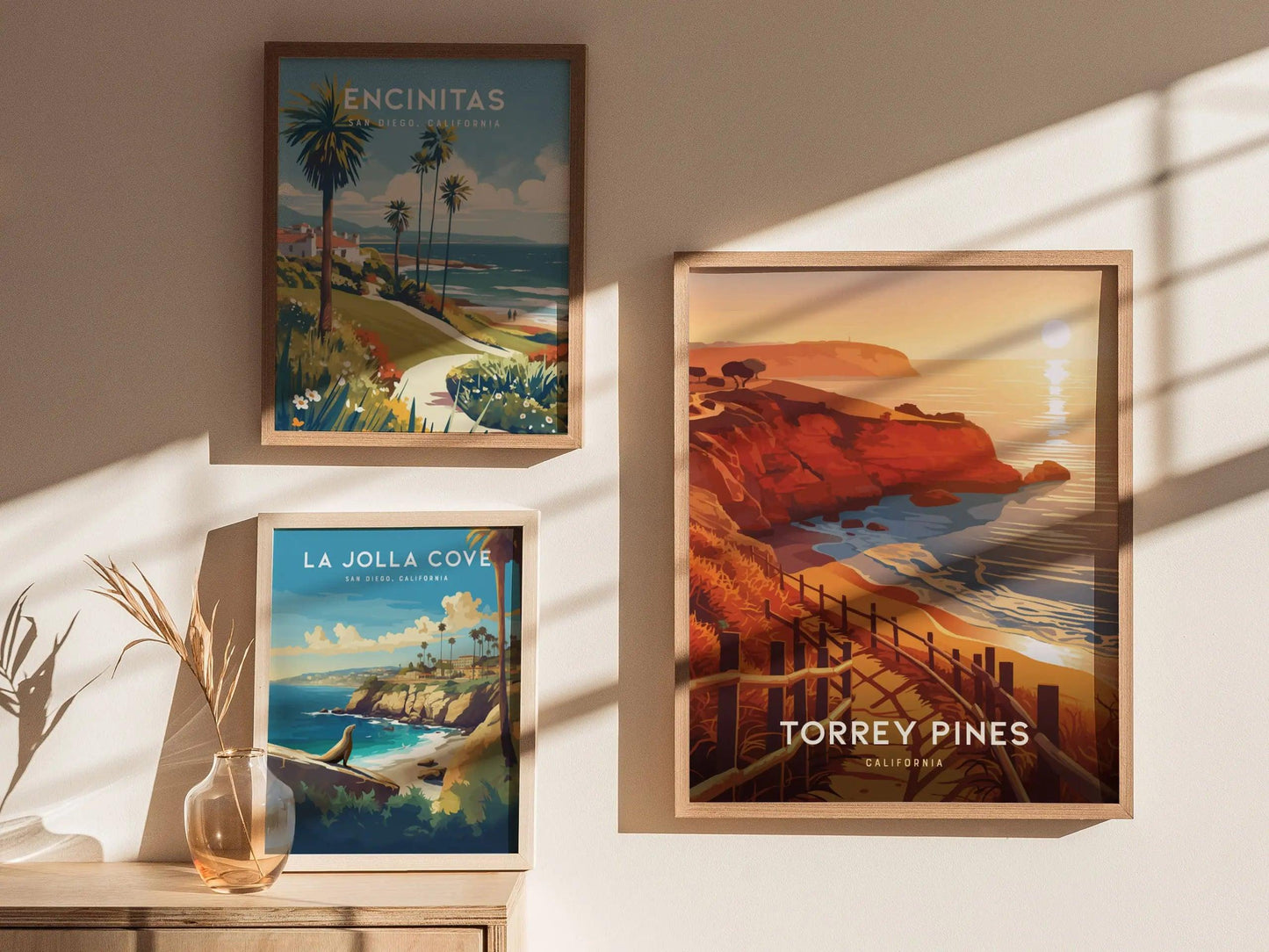 Framed posters of scenic locations on a wall with sunlight casting shadows.