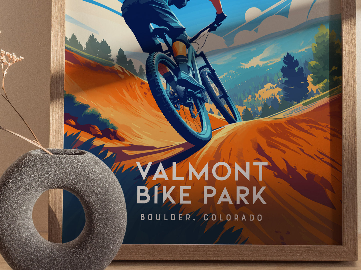 Framed poster of a mountain biker at Valmont Bike Park with a decorative vase in the foreground.