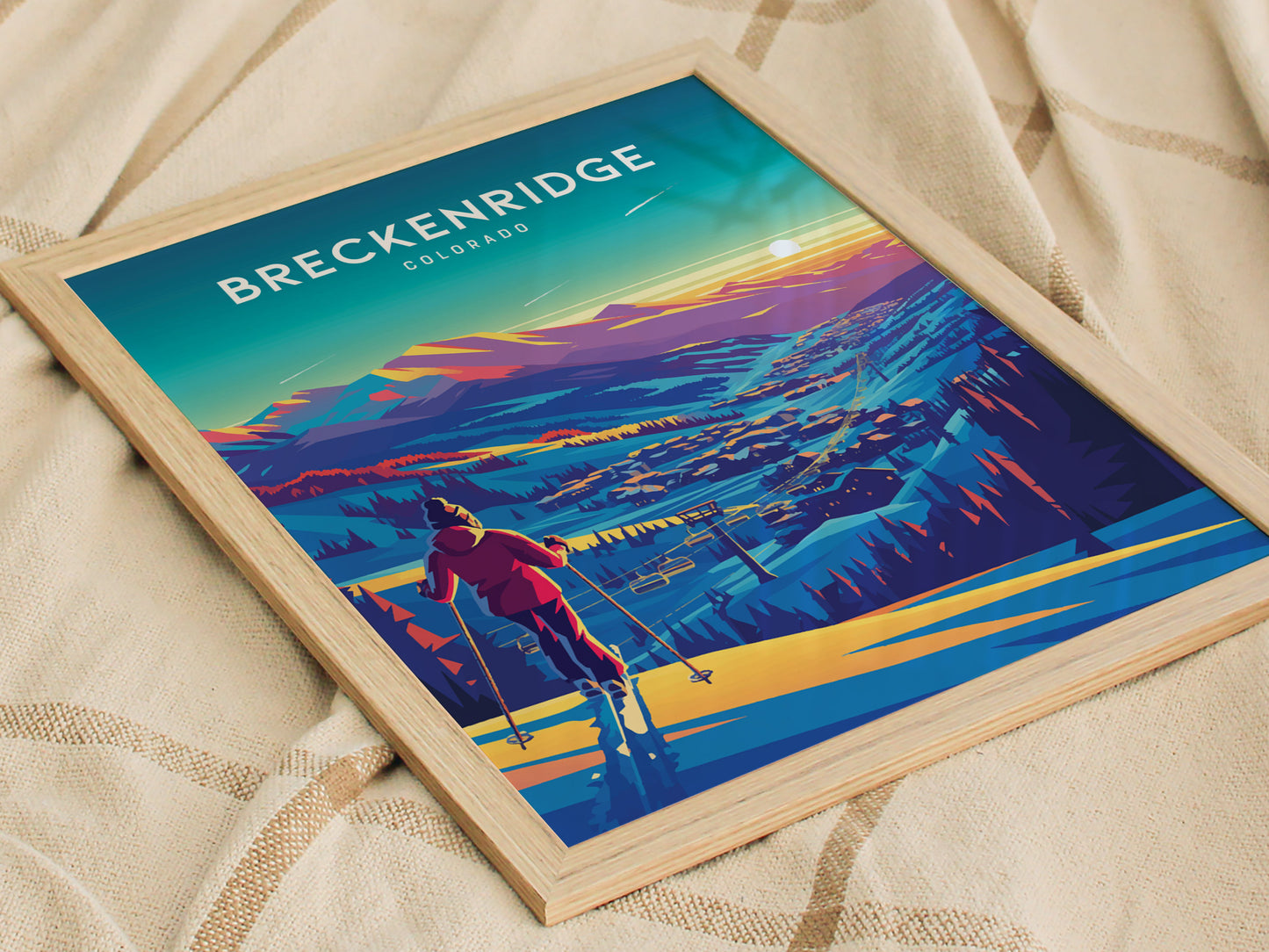 A vibrant poster of Breckenridge, Colorado, showcasing a skier overlooking the resort with colorful mountains and a glowing sunset. The artwork is framed with a light wood border.