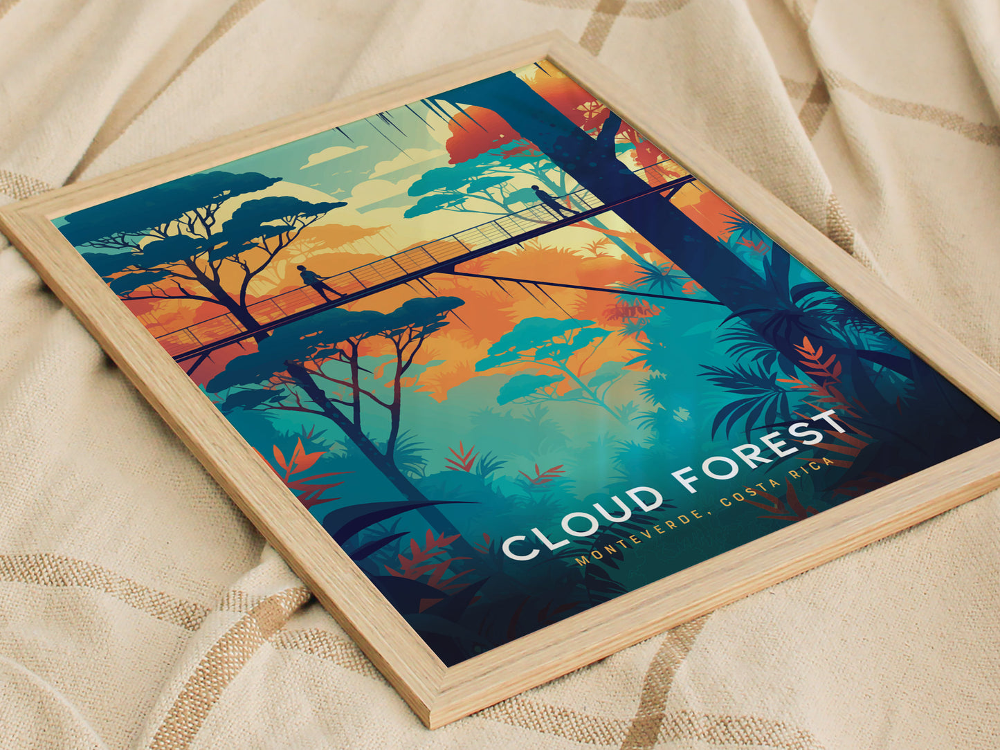 A vibrant poster depicting a person walking across a canopy bridge surrounded by lush, colorful trees with Cloud Forest Monteverde, Costa Rica text, framed in light wood.