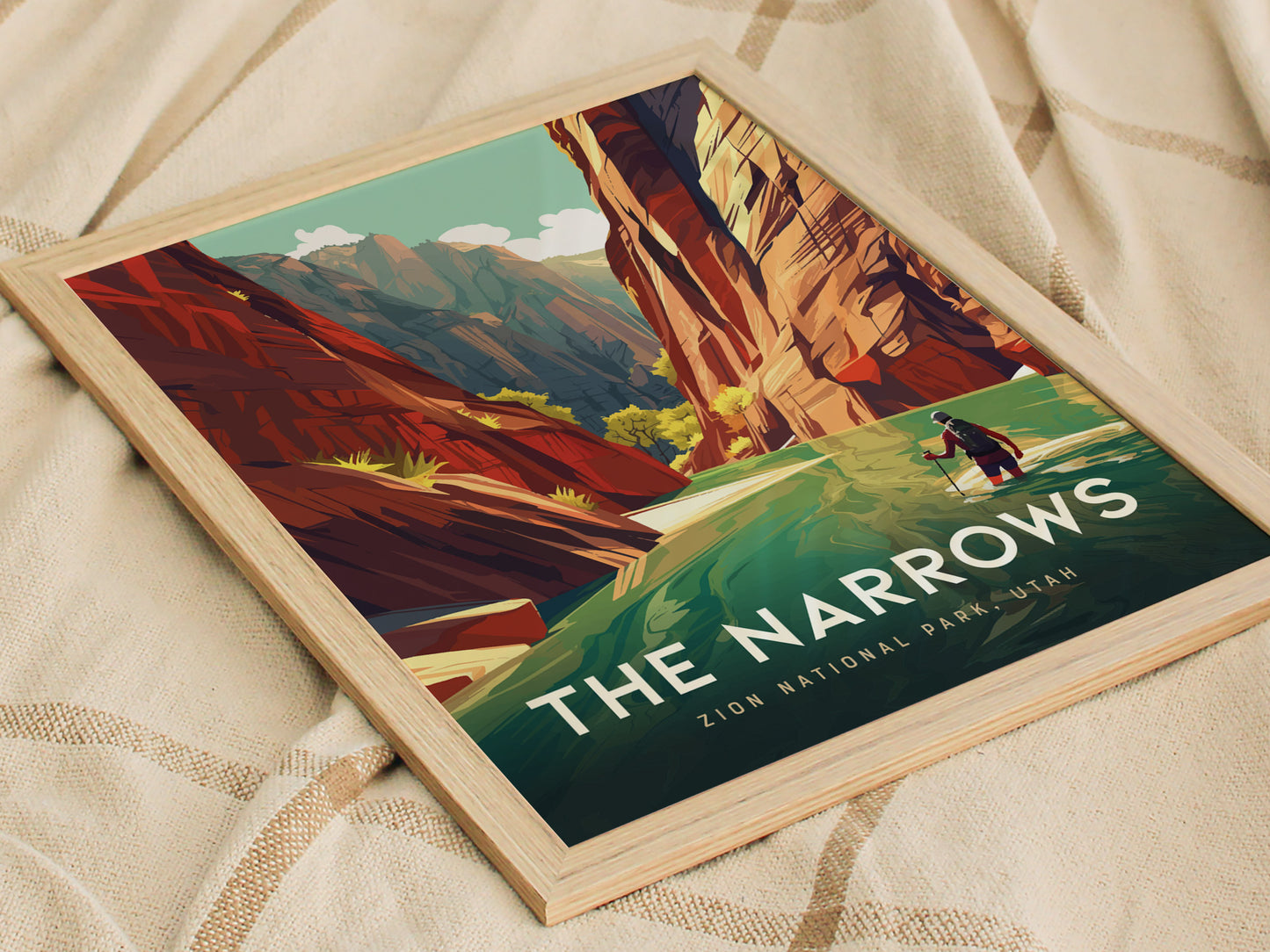 Poster of The Narrows in Zion National Park features a hiker wading through a river flanked by towering canyon walls, framed on a beige fabric background.
