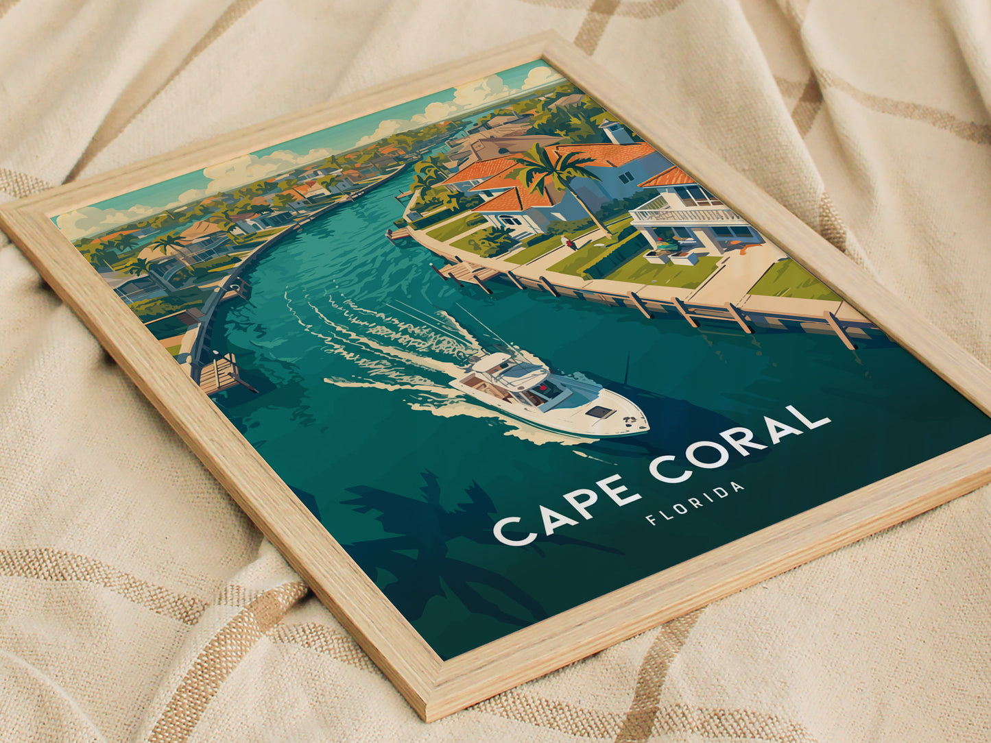 Framed poster depicting a vibrant illustration of Cape Coral, Florida, featuring a canal with a boat, tropical homes, and palm trees. The scene captures coastal charm and tranquility.