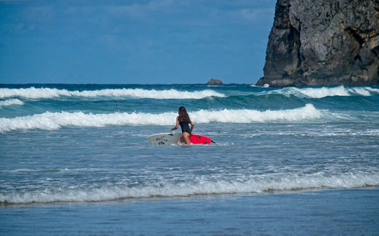 woman in red bikini surfing on sea waves during daytime