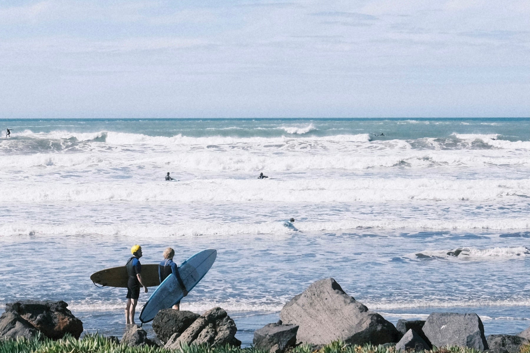 a man holding a surfboard on top of a beach