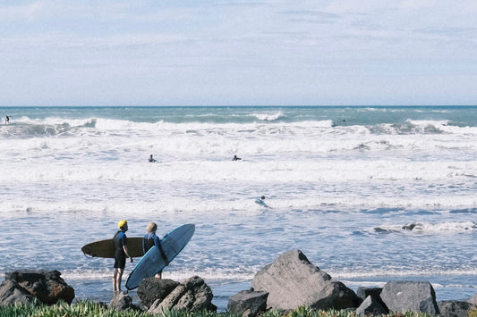 a man holding a surfboard on top of a beach