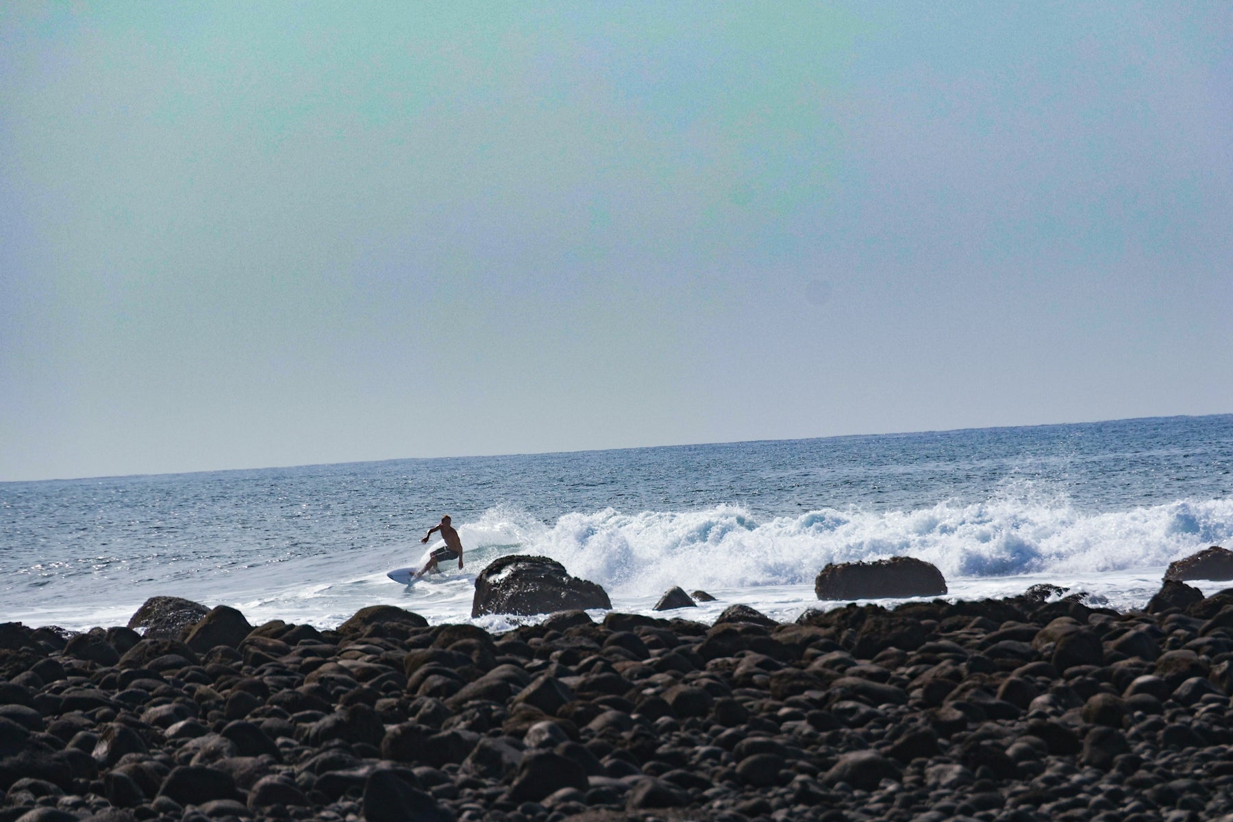 A surfer rides a wave in the ocean.