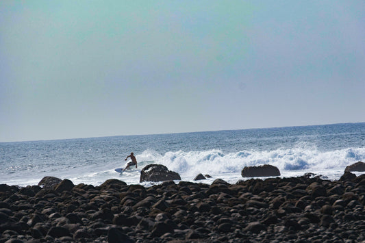A surfer rides a wave in the ocean.