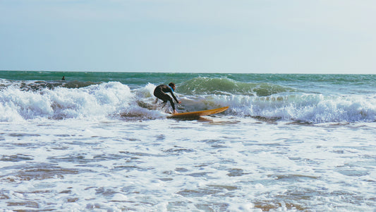 A surfer rides a wave in the ocean.