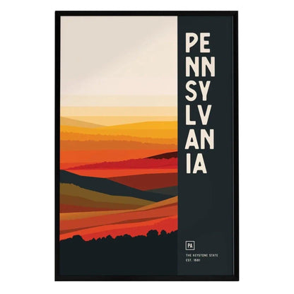 A framed poster featuring an abstract representation of Pennsylvania, showcasing layered hills in warm tones of orange, yellow, and red. The word PENNSYLVANIA is prominently displayed in bold letters on the left side.