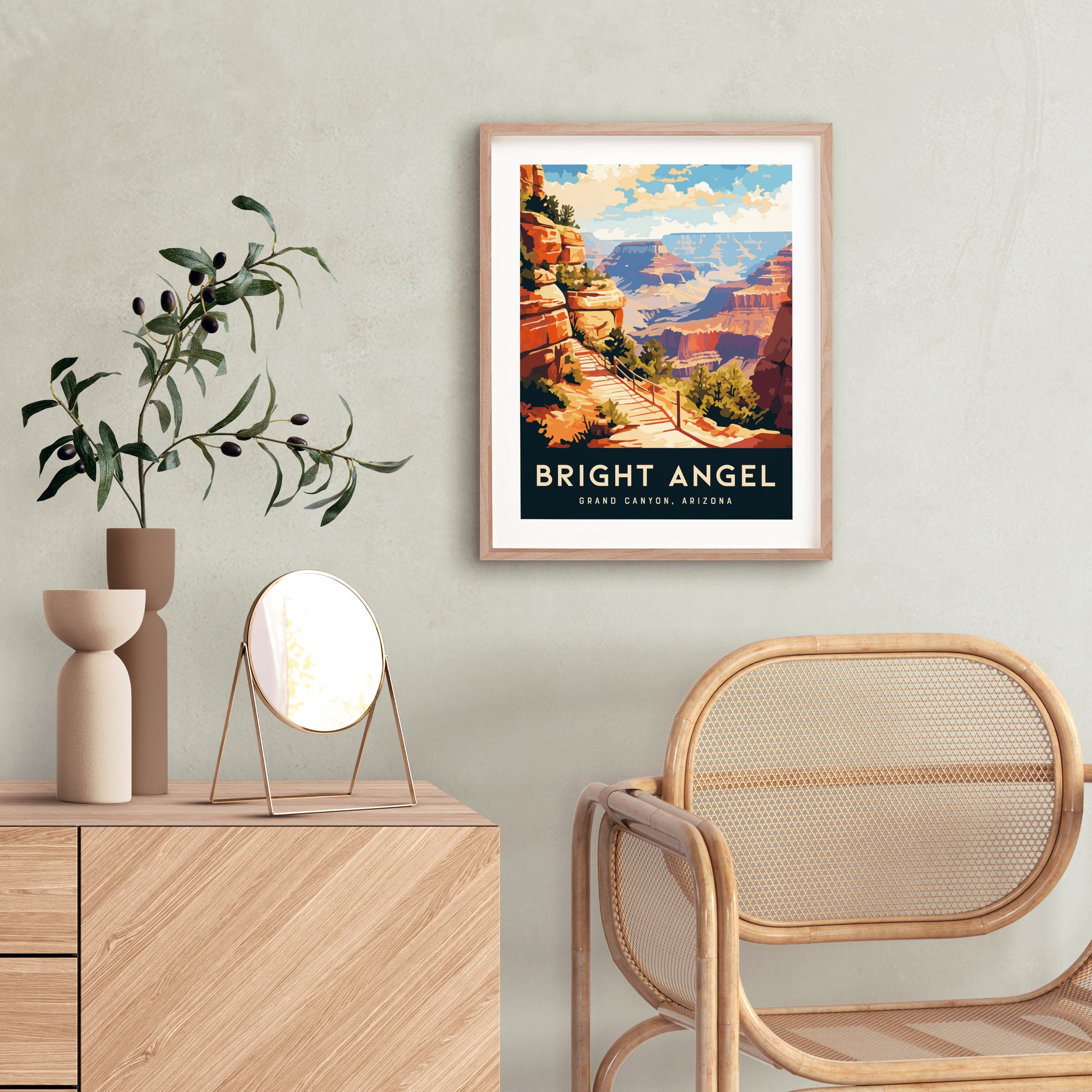 A framed Bright Angel poster hangs on a light-colored wall, depicting a scenic view of the Grand Canyon. A wooden dresser with a small round mirror and vase sits nearby.