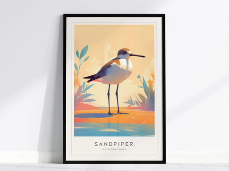 Framed poster featuring an illustrated sandpiper standing by water with colorful foliage, set against a warm pastel background. The word Sandpiper is printed below the image.