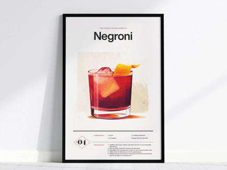 Framed Negroni cocktail poster featuring a vibrant illustration of the drink in a glass with an orange peel garnish, set against a light background. Recipe details are included below.