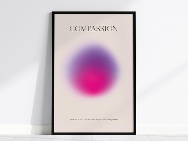 Framed poster featuring the word Compassion at the top with a vibrant pink and violet gradient in the center. Below, the text reads, “Awaken your purpose and inspire with compassion.”.