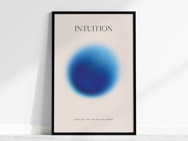 A framed poster features a soft blue gradient circle with the word INTUITION above it and a motivational phrase below. The background is a light, neutral color.