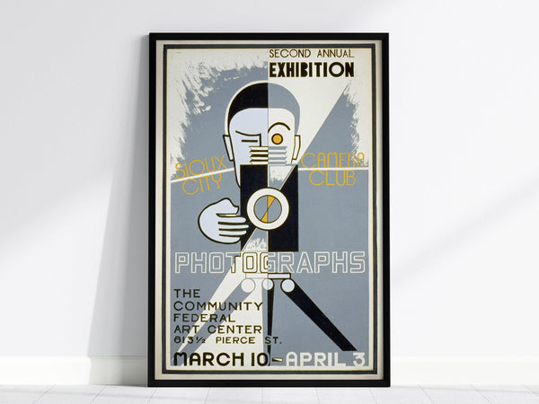 Art Deco poster featuring a stylized photographer with a vintage camera, promoting the Sioux City Camera Clubs Second Annual Exhibition. Includes bold typography and geometric shapes in a framed design.