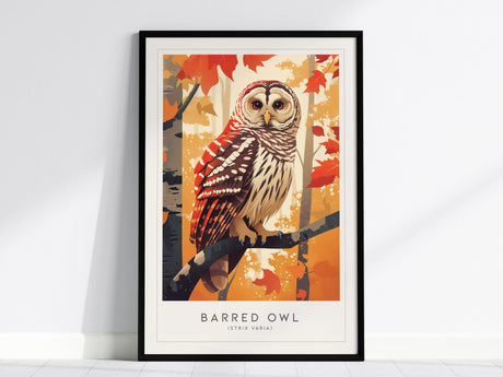 A framed print of a Barred Owl perched on a branch, surrounded by vibrant autumn leaves in shades of red and orange, against a warm background.