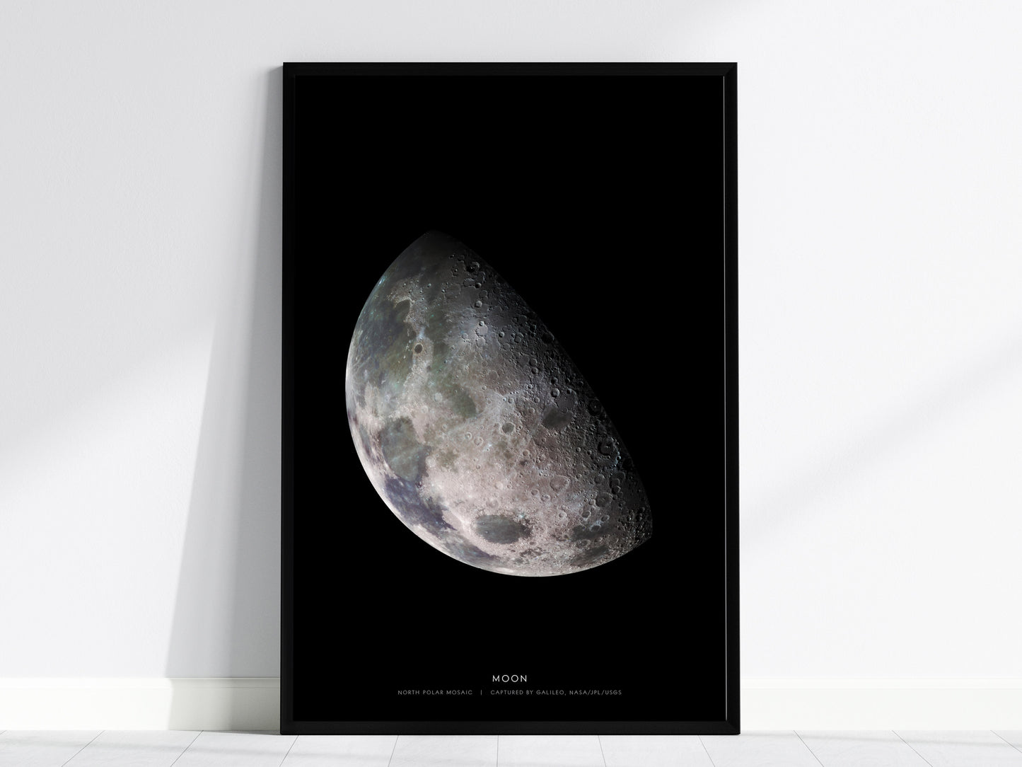 Black framed print of the moon's surface on a white wall