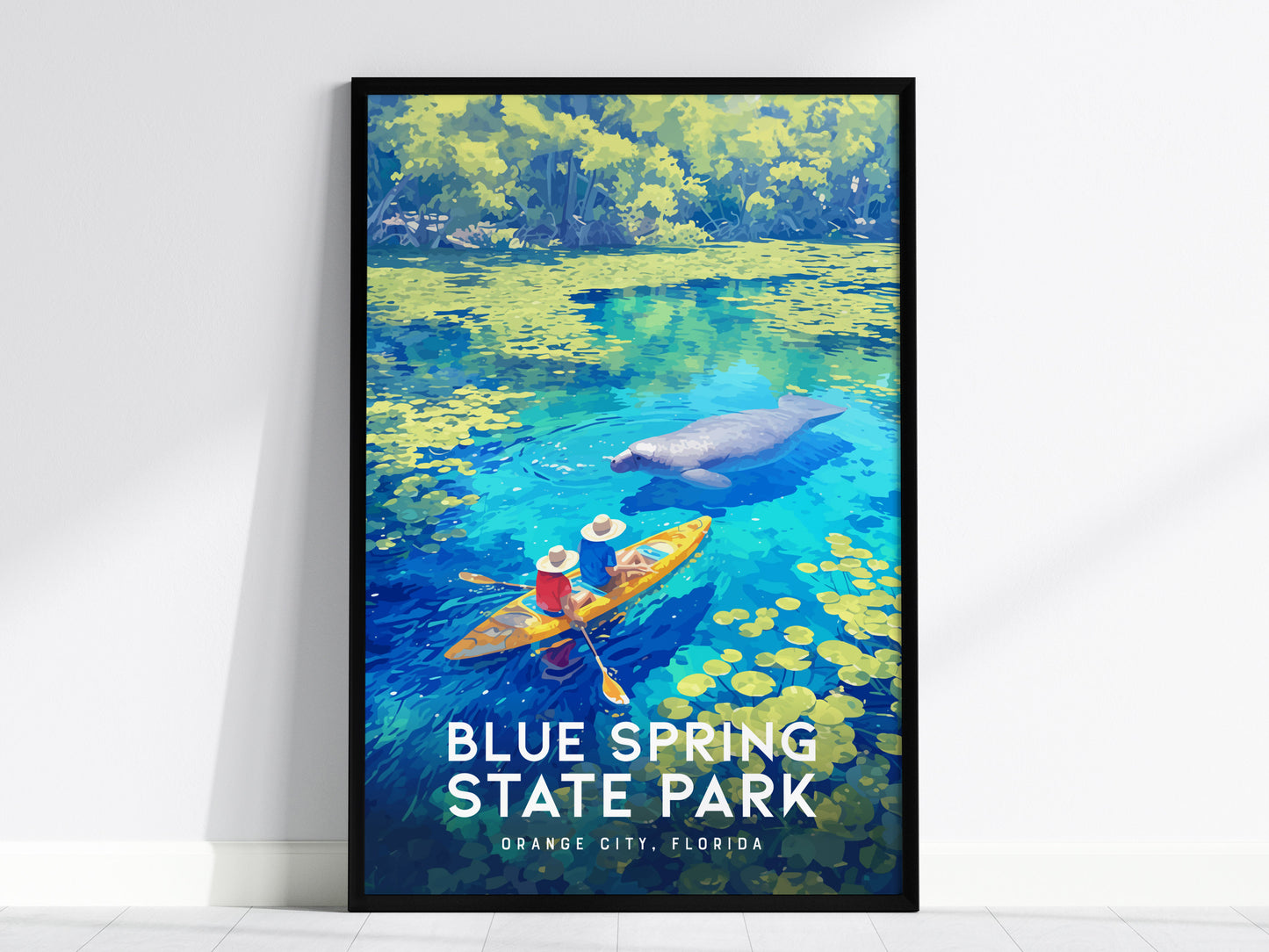 A framed poster displays an illustration of two kayakers near a manatee in vibrant blue waters surrounded by lush greenery, titled Blue Spring State Park, Orange City, Florida.