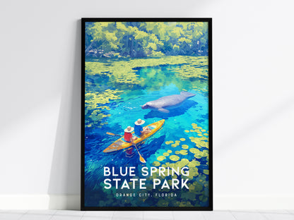 A framed poster displays an illustration of two kayakers near a manatee in vibrant blue waters surrounded by lush greenery, titled Blue Spring State Park, Orange City, Florida.