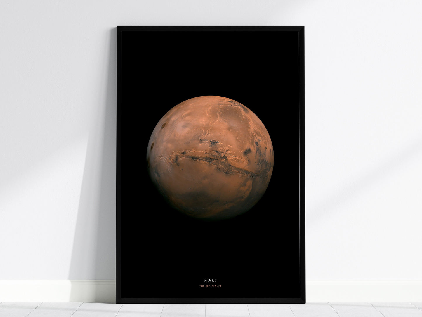 Black framed poster of Mars on a white wall