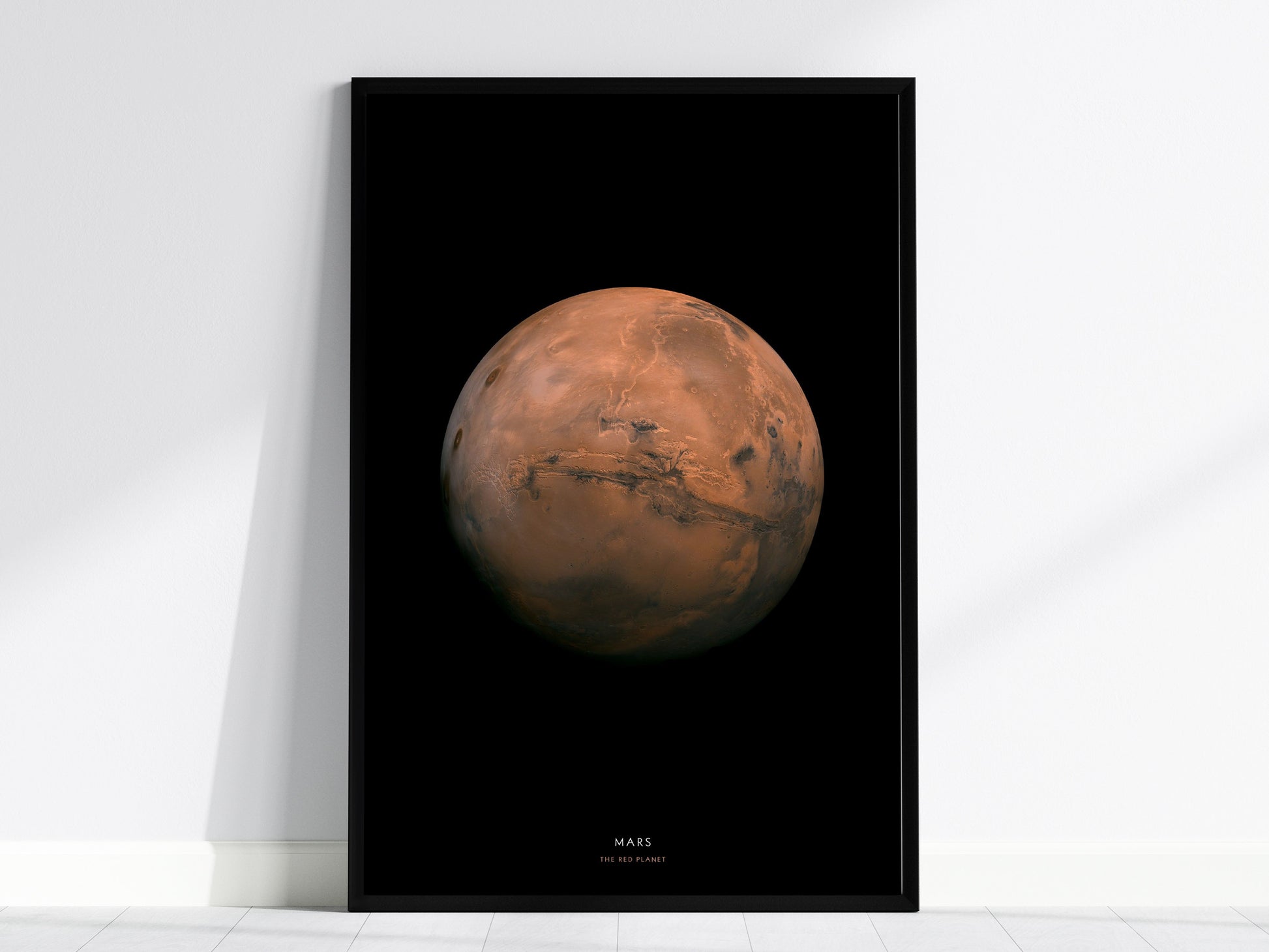 Black framed poster of Mars on a white wall