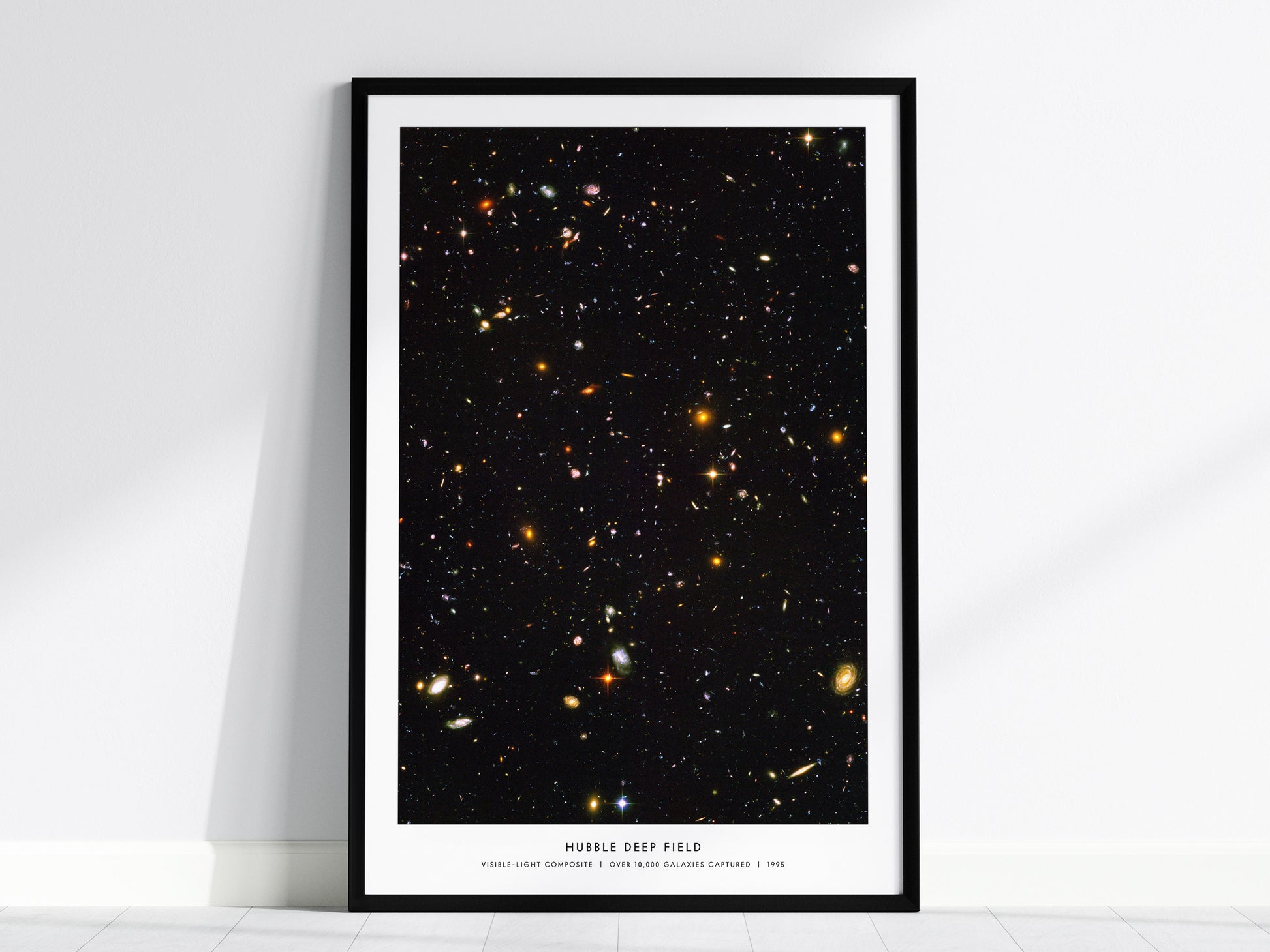 Framed poster of the Hubble Deep Field with a black frame on a white wall.