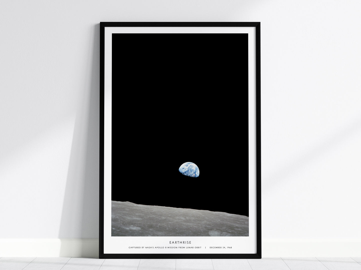 Framed Earthrise Apollo 8 wall art hanging on a white wall in a modern living room