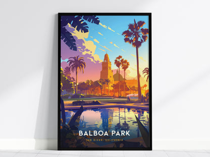 Framed poster featuring an illustration of Balboa Park, showcasing palm trees, Spanish Colonial architecture, and a vibrant sunset sky reflected in a tranquil pond.