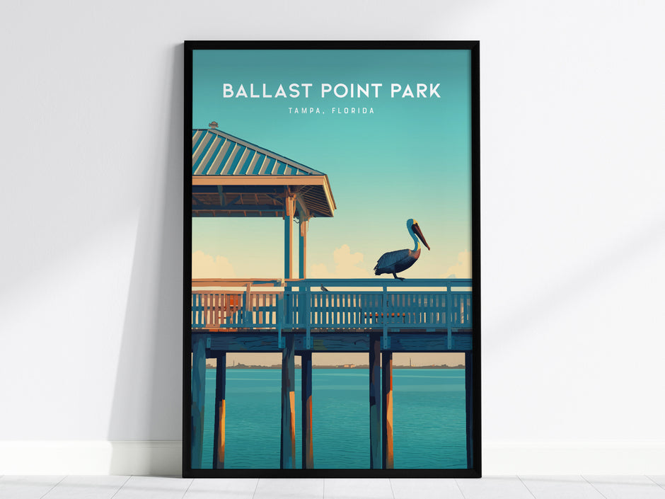 A framed poster of Ballast Point Park, Tampa, Florida, featuring a pelican perched on a wooden pier under a clear blue sky and calm water.
