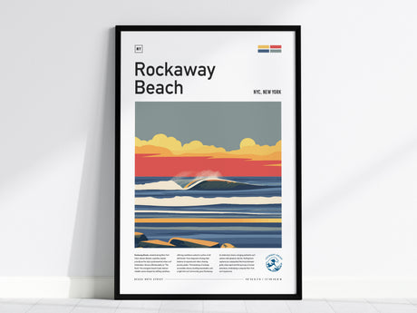 A framed poster of Rockaway Beach featuring a stylized illustration of ocean waves under a colorful sky with a setting sun. The poster includes bold text and a modern design, set against a white wall and a light floor.