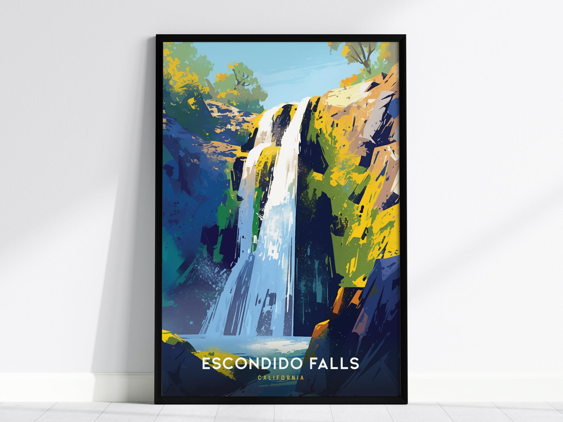 A vibrant art print of Escondido Falls, California, featuring a cascading waterfall surrounded by colorful rocks and greenery, framed and leaning against a white wall.