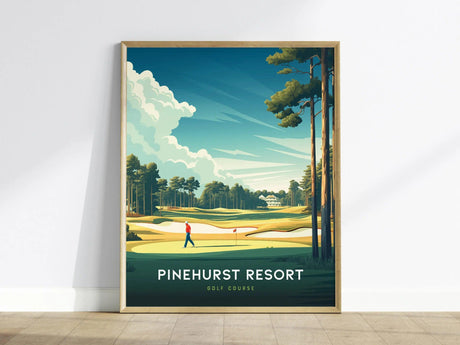 Framed poster of Pinehurst Resort golf course art, featuring a golfer on lush greens, tall pines, and vibrant skies, leaning against a white wall.