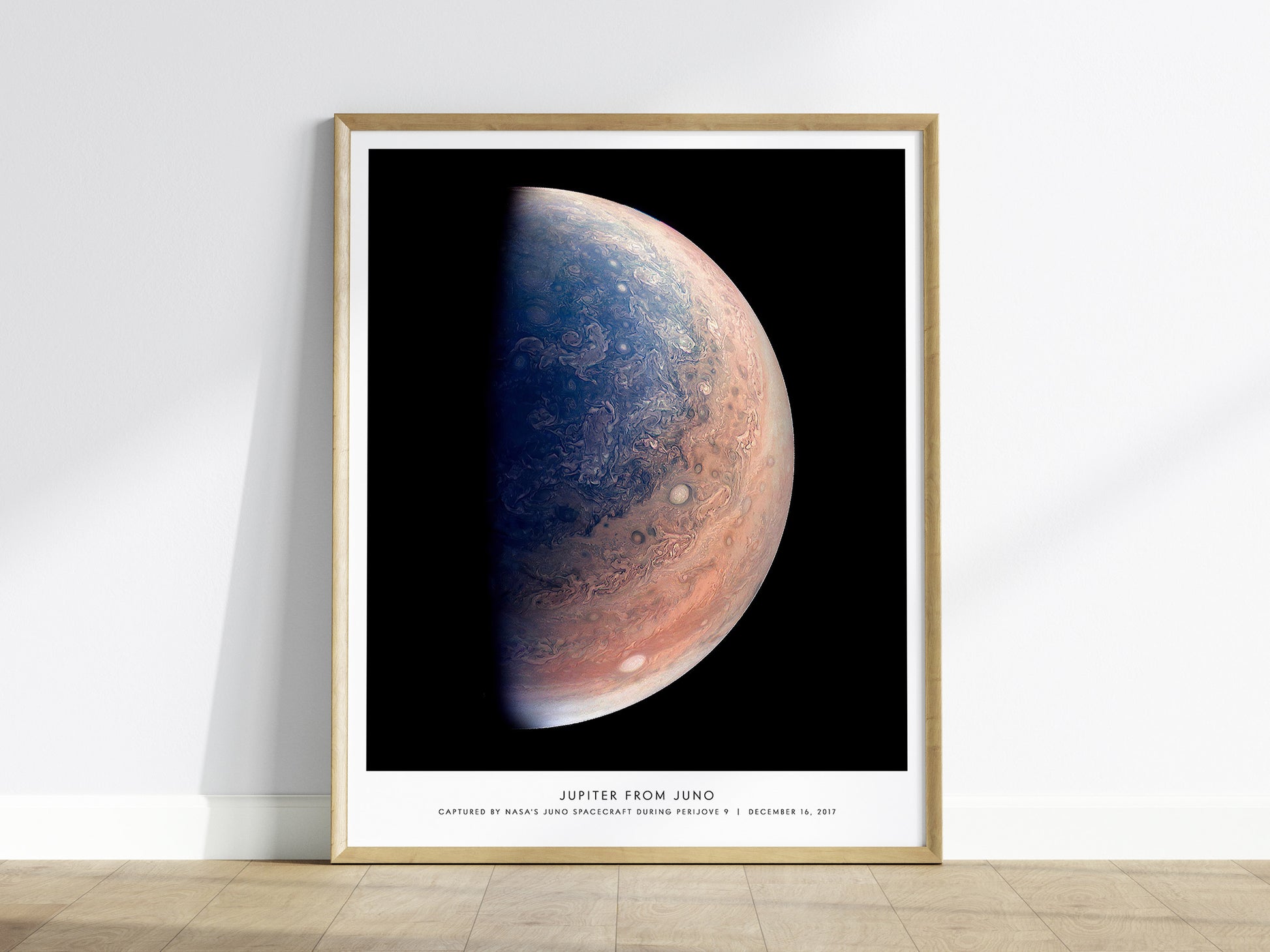 Framed poster of Jupiter from Juno on a white wall.