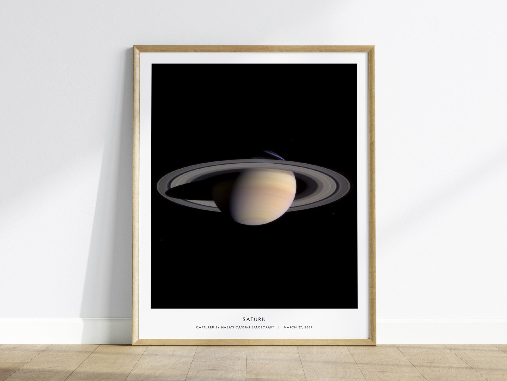 Framed poster of Saturn on a white wall
