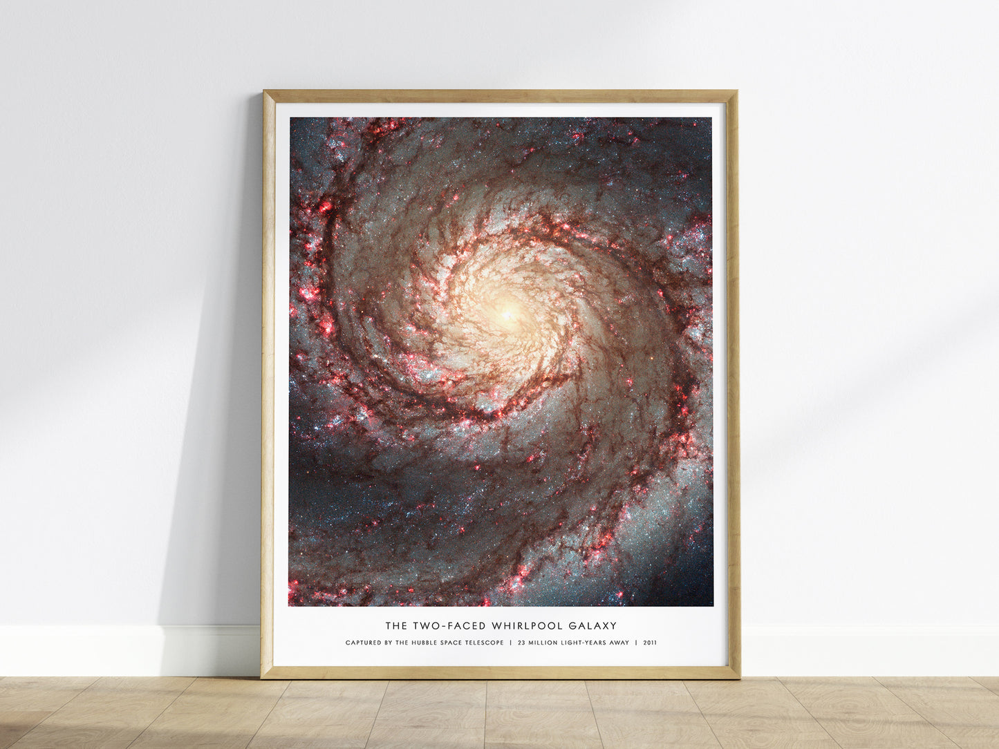 Framed Whirlpool Galaxy M51 Hubble wall art hanging on a white wall in a modern living room