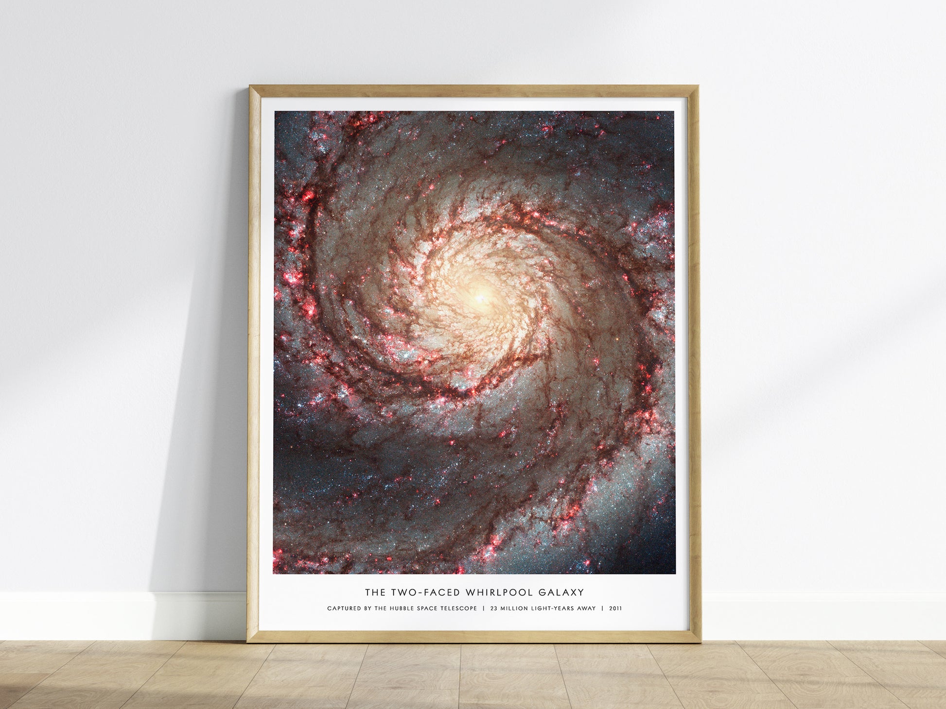 Framed Whirlpool Galaxy M51 Hubble wall art hanging on a white wall in a modern living room