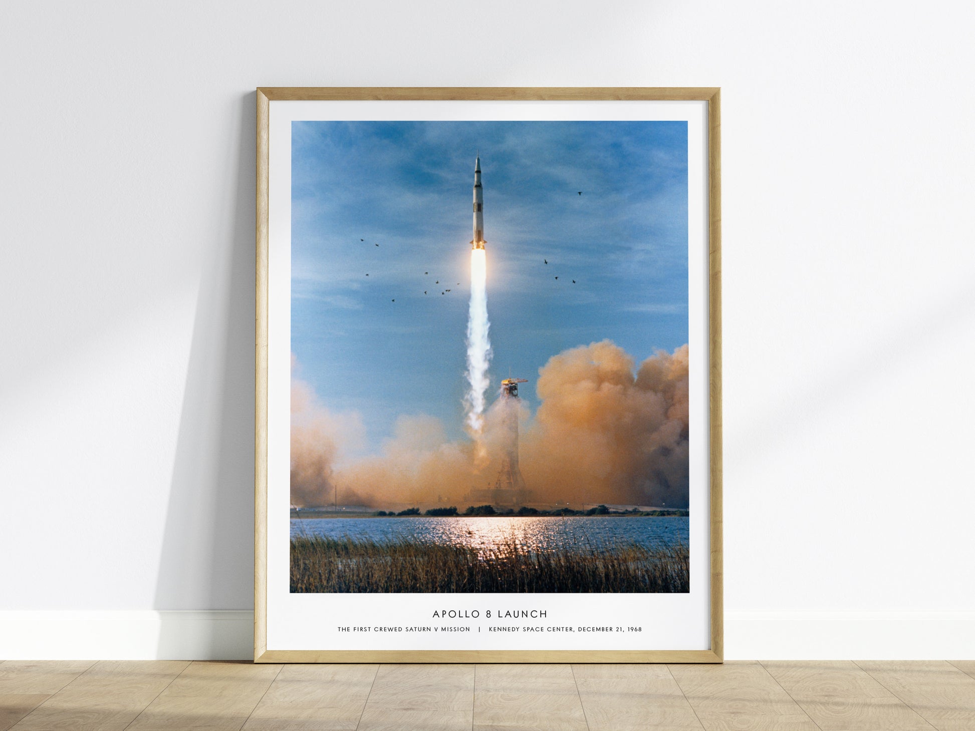 Framed Apollo 8 launch NASA wall art displayed on a white wall in a modern living room