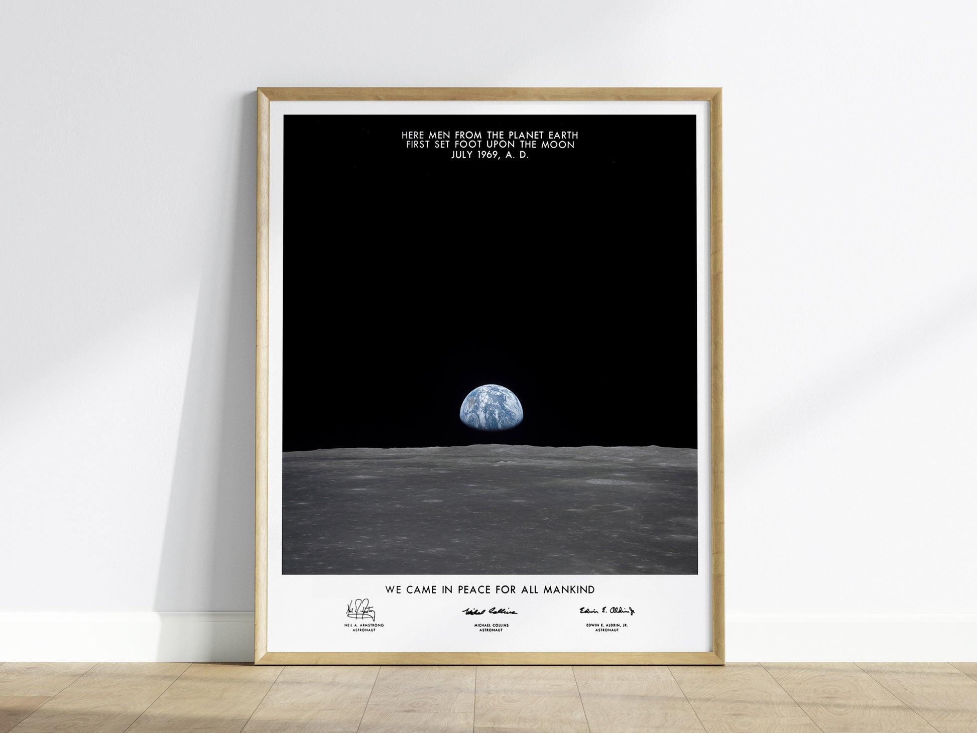 Framed Apollo 11 Earth on the Horizon wall art hanging on a white wall in a modern living room
